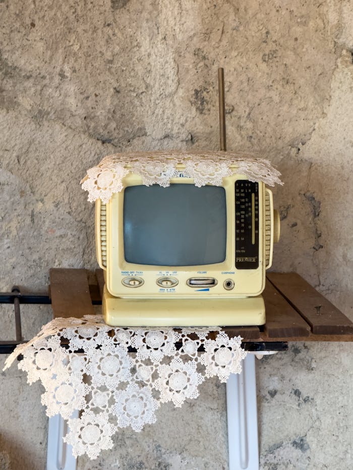 Old-fashioned TV in rustic setting, covered with lace, in Palu, Türkiye.